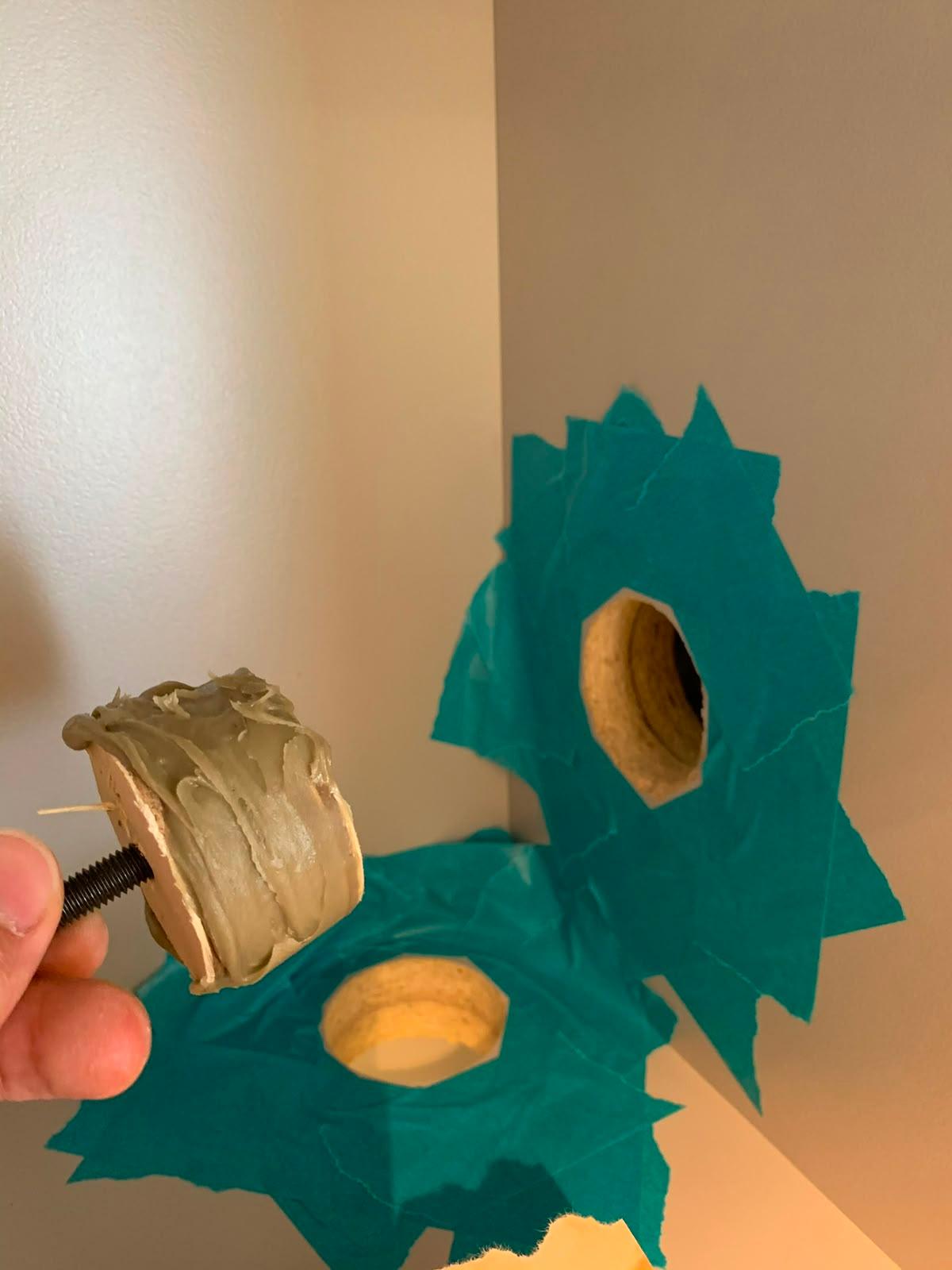 A filler-coated timber plug held over the masked holes